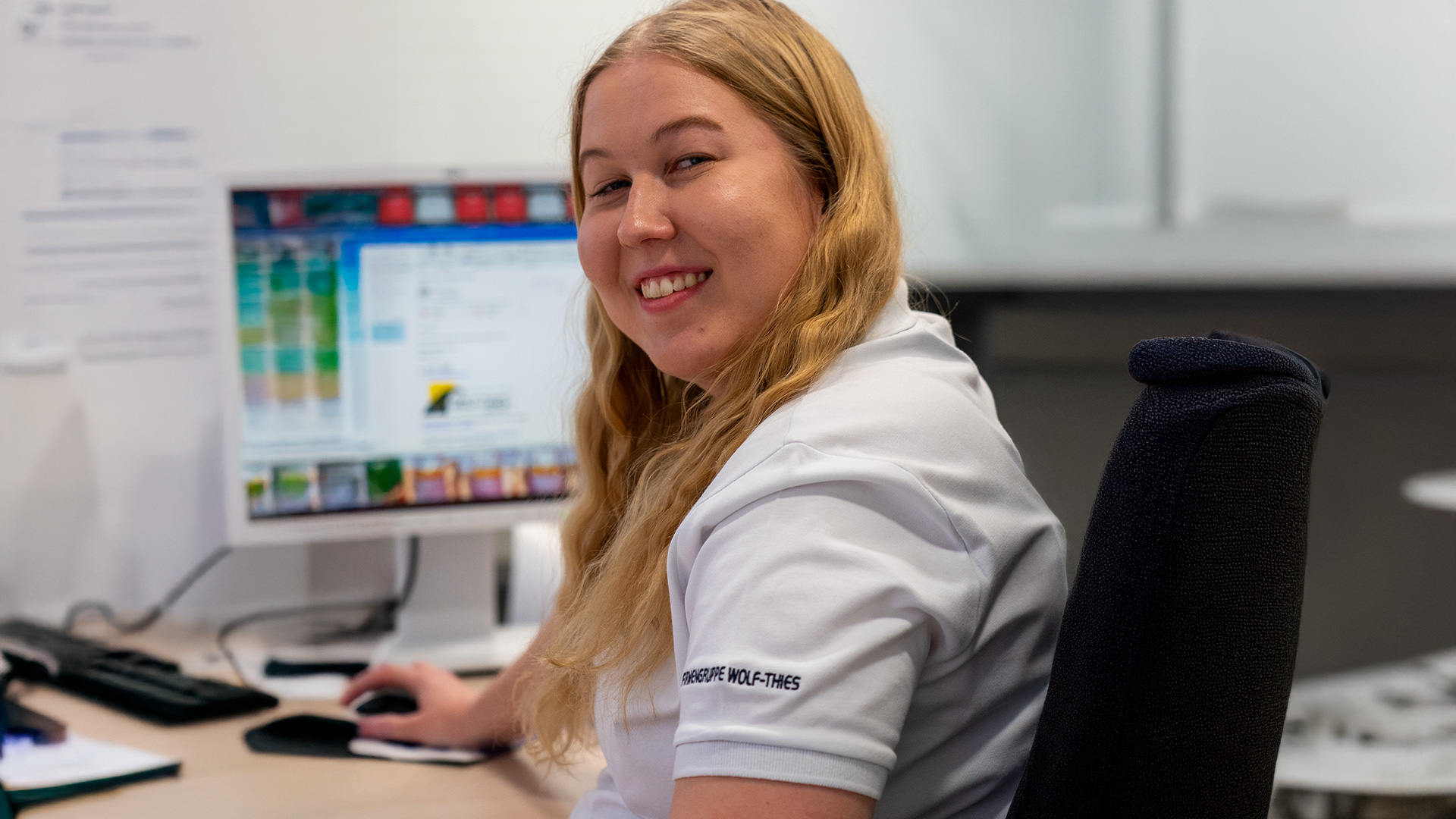 Auszubildende zur Bürokauffrau sitzt an ihrem Rechner im Büro